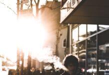 구취 예방과 치료: 입 냄새를 없애는 방법 man walking on sidewalk beside glass wall