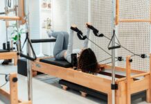 근력과 유연성을 향상시키는 필라테스 a woman is doing exercises on a rowing machine