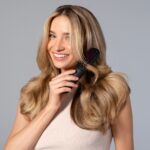 두피 관리와 맞춤형 영양, 헤어 건강의 새로운 트렌드 a woman holding a hair brush in her hand